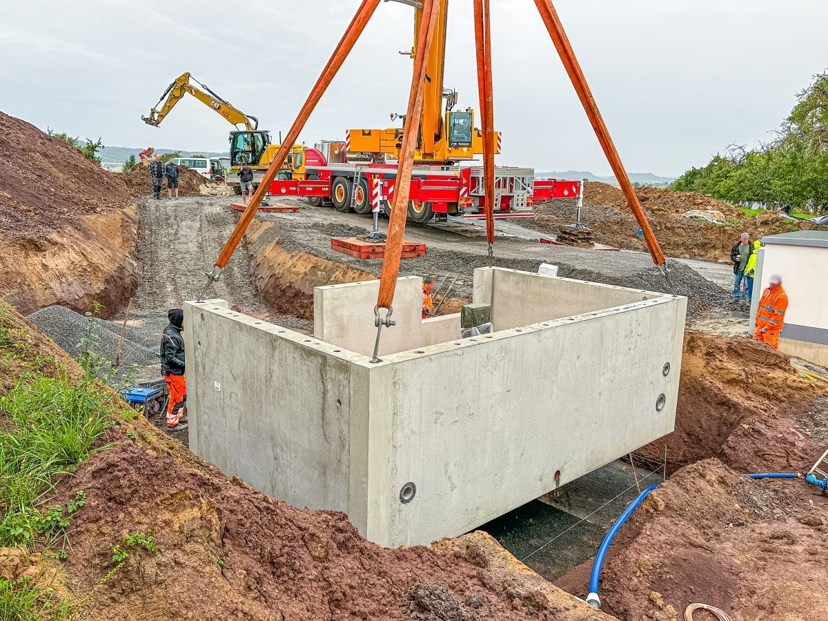 Das erste von sechs Bauwerken wird in die Baugrube versetzt