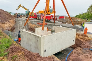  Das erste von sechs Bauwerken wird in die Baugrube versetzt 